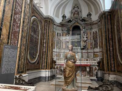 ..., ci troviamo nella navata laterale del tempio, l� dove davanti a un altare barocco si erge la splendida statua, conservata in una teca di vetro